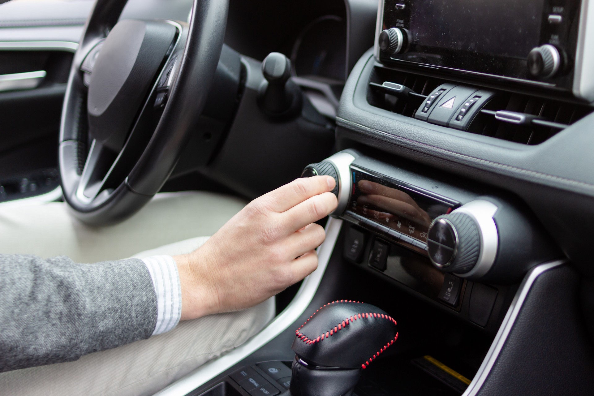 Businessman adjusting car temperature inside modern vehicle