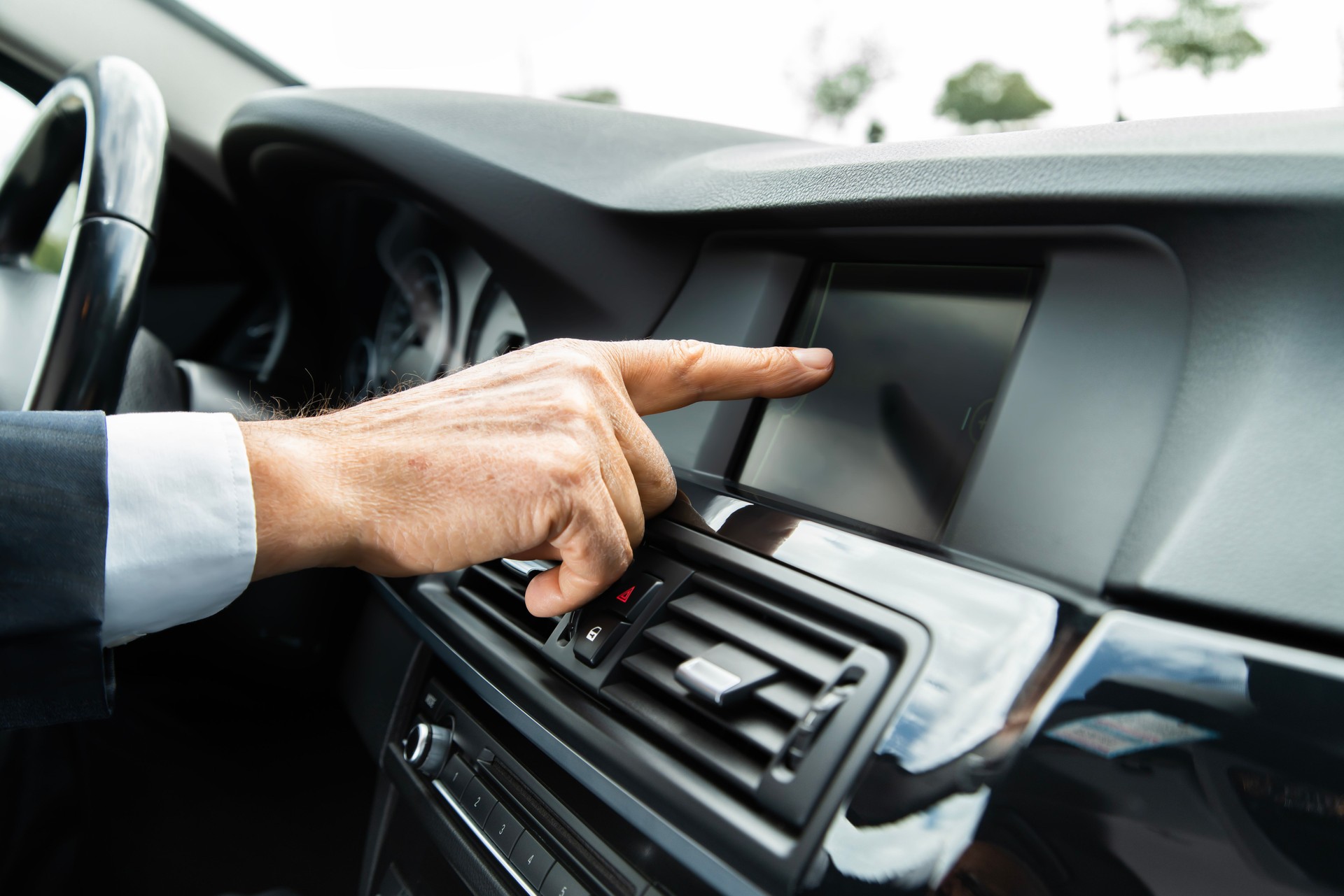 Man hand touching the LCD screen in the car